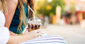 A woman holding an iced coffee